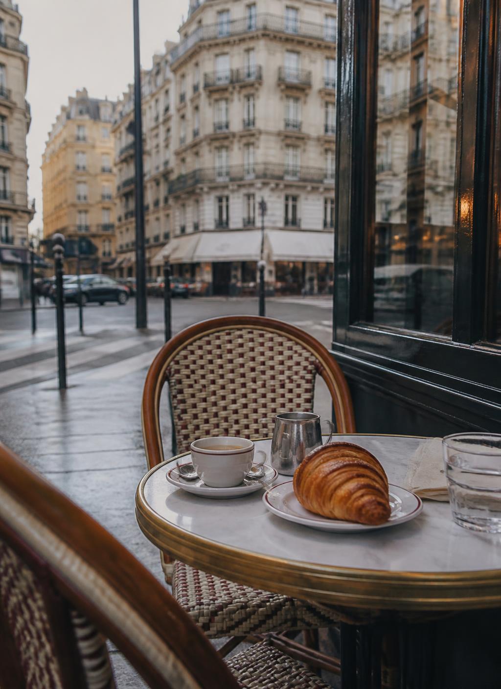 Café parisino con espresso y croissant en una mesa de mármol